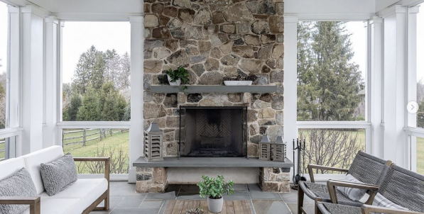 Living room with a stone fireplace and modern seating.